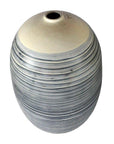 Close-up of large white ceramic vase with blue-gray stripes and a crackled finish.