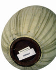 White ceramic vase upside down, barcode sticker and Made in Thailand label visible on base, close-up.