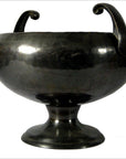 Close-up of a metallic hammered Asian bowl with two handles, wide opening, and short base; in good condition.