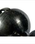 Close-up of black hammered metal bowl with handle, shiny finish, round shape, in good condition on white background.