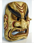 Close-up of a hand carved wood Balinese Dancing Mask with fierce expression, wide eyes, and flared nostrils.