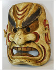 Close-up of a Balinese dancing mask with exaggerated features, red and black accents, intense expression.