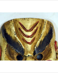 Close-up of black and red hand-carved wooden Balinese dancing mask on a light background.