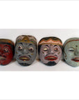 Colorful vintage Balinese dancing masks with unique expressions, arranged in a row on a white background.