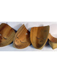 Brown and white carved Balinese masks, wood material, arranged in a row on a plain white background.