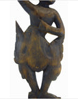 Wooden Balinese hand carved temple dancer figure with bent arms and legs in a skirt, white background.