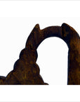 Close-up of tan wood hand-carved temple dancer wall decor, arch-shaped with jagged edge.