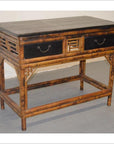 Black lacquered and bamboo desk with two drawers on a light gray wooden floor.