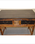 Black lacquered and bamboo desk with two drawers on gray floor.