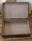 Natural bamboo trunk with lid open, interior visible, placed on a wooden floor.