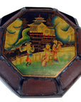 Black lacquer octagonal tray with basket-like edges, Asian figures, trees, and pagoda decoration.
