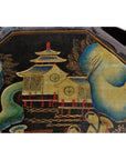 Close-up of black lacquer painting with Asian-style pagoda, trees, people, and basket with top detail.