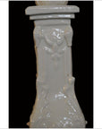 White Blanc de Chine porcelain candle holder, ornate design, close-up against a black background.