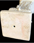 White porcelain candle holder base with small central hole, close-up, black background.