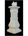 White porcelain candle holder with ornate floral details and square base, close-up on black background.