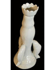White porcelain candle holder with dolphin handles, Blanc de Chine, close-up against a black background.