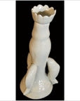 White porcelain candle holder with dolphin handles, Blanc de Chine, close-up against a black background.