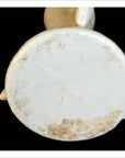 Close-up of the base of a white Blanc de Chine porcelain candle holder with dolphins, showing edge wear and discoloration.