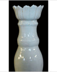 White Blanc de Chine porcelain candle holder with duck motifs, close-up against a black background.
