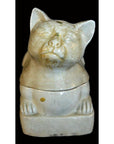 White porcelain Blanc de Chine cat on a rectangular base, close-up, set against a black background.