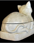 Cream-colored porcelain cat with crackled glaze, viewed from back and side against black background.