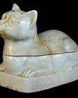 White porcelain reclining cat container with lid, Blanc de Chine style, close-up on black background.