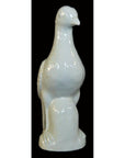 White porcelain dove figurine, Blanc de Chine, against black background.