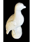 White porcelain dove with textured wings, Blanc de Chine style, against a black background.