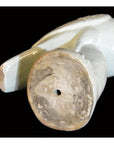 White porcelain dove figurine lying on its side with unglazed round base and small center hole visible.