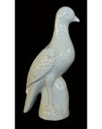 White porcelain dove figurine with detailed wings, Blanc de Chine, close-up against a black background.