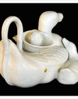 White porcelain duck dish with basket detail, small duck inside, displayed on a flat surface.