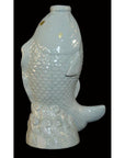 White porcelain fish figurine with detailed scales and waves on a black background.