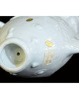 White porcelain fish with two gold stickers, including one reading "Made in China," on a black background.