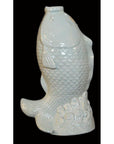White porcelain fish with open mouth, detailed scales, and wave design on black background.