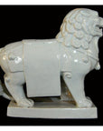 White porcelain Foo-Dog with stylized mane and draped cloth on rectangular base, close-up.