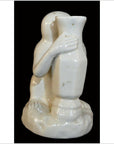 White Blanc de Chine porcelain monkey sculpture hugging a tall vase, detailed arms, hands, and feet, close-up.