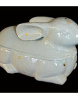 White porcelain rabbit box with lid, Blanc de Chine style, close-up on a black background.