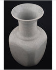 White porcelain vase with wide rim and fine crackle glaze, close-up against a black background.
