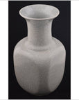 White Blanc de Chine porcelain vase with crackle glaze, close-up on black background.