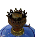 Close-up of a rusty burner on an antique blue glass oil lamp in very good condition, set against a white background.