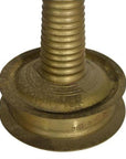 Close-up of brass incense burner base with engraved patterns and spiral design.