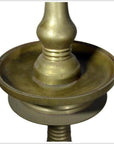 Close-up of brass incense burner with spiral design and round base on white background.