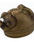 Close-up of a solid brass monkey head box with large teeth, a stylized mane, and engraved eyes.