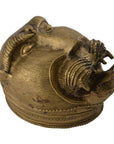 Brass monkey head box with textured surface and horns, tribal baboon style, close-up.