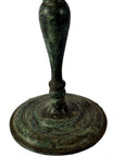 Close-up of greenish bronze candelabra with slender stem, lost wax casted.