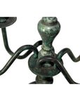 Close-up of bronze candelabra with three curved arms, lost wax casted, on a plain white background.