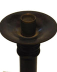Close-up of dark bronze Japanese candle holder with wide shallow dish and cylindrical center.
