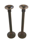 Bronze candle holders with round bases and classic Japanese design, close-up view, standing side by side.