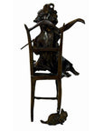 Bronze sculpture of a woman draped over a chair with one arm raised, small mouse at the base, close-up view.