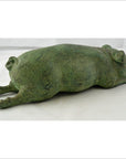 Greenish bronze pig sculpture lying flat with outstretched legs, ideal as tabletop decor, close-up view.